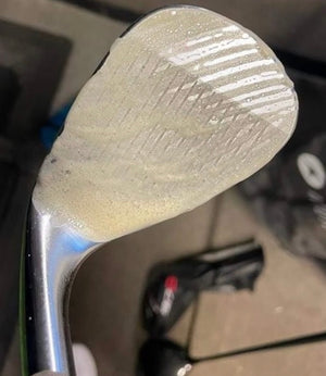 a picture of a golf club that has golfs green jacket cleaning solution added which will remove all dirt and grime from the gold club head. 